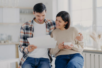 Couple reading documents while sitting at home