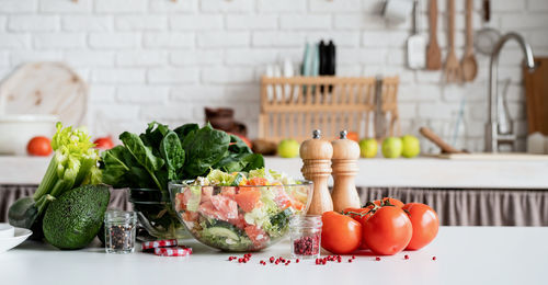 Healthy eating. front view of kitchen table with a bowl of greek salad and ingredients