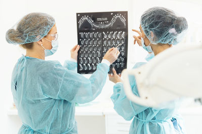 Female dentists examining x-ray at clinic