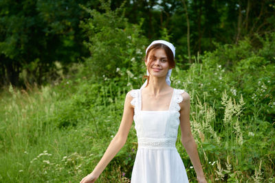 Portrait of young woman standing on field