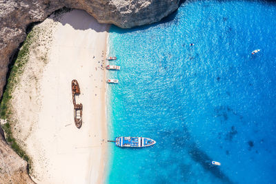 Aerial view of shipwreck at beach and boat in sea 
