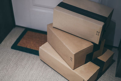 Stack of brown cardboard boxes in front of the house door. order on delivery, box on the doormat. 