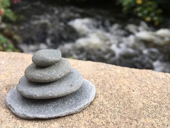 Stack of pebbles on sand at shore