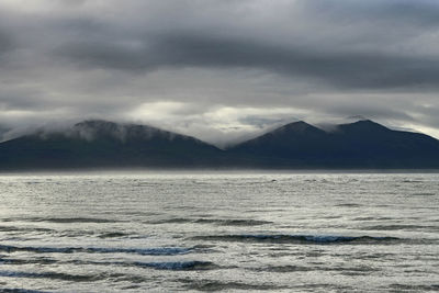 Scenic view of mountains against cloudy sky