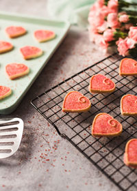 Close up of valentine's day heart cookies cooling on a pan and rack.