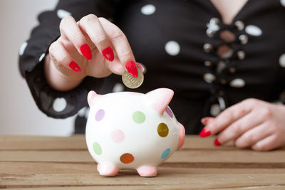 Midsection of woman holding ice cream cone on table