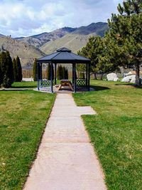 Footpath leading towards mountains against sky