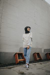 Portrait of woman standing against wall