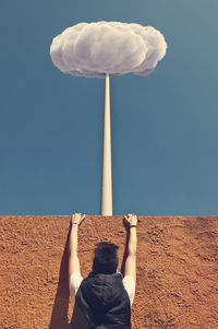 Rear view of man climbing on wall