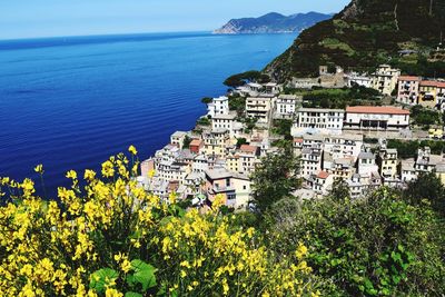 Scenic view of sea by townscape against sky