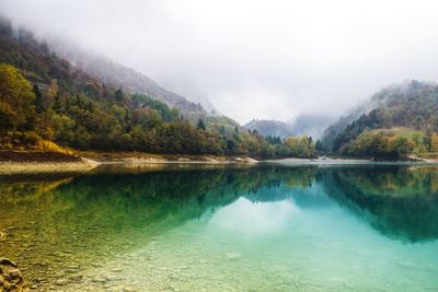 Scenic view of lake by mountains against sky