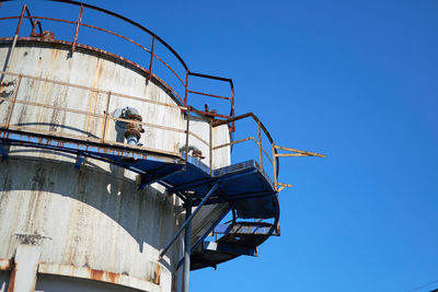 Low angle view of factory against clear blue sky