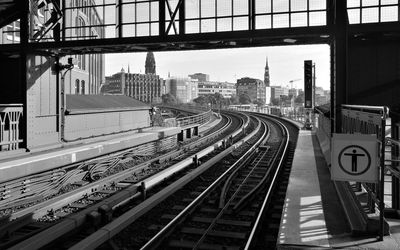 Railroad tracks in city against sky