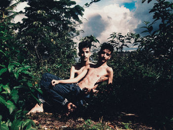 Young couple on land against trees