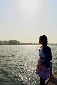 Silhouette of woman standing by lake