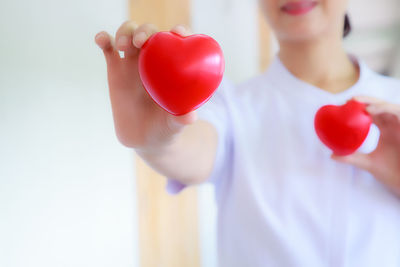 Midsection of woman holding red balloons