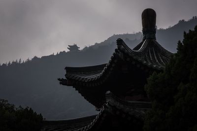 Low angle view of temple and building against sky