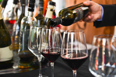 Bartender pouring wine in glass at bar