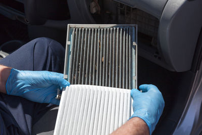 Cropped hands of man holding car air filter