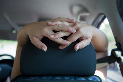 Cropped image of woman hands in car seat