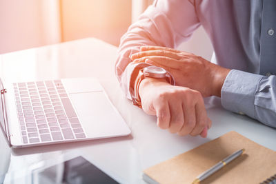 Close-up of woman using laptop on table