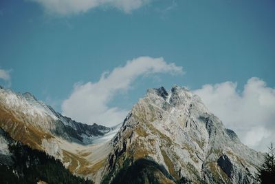 Low angle view of snowcapped mountains against sky