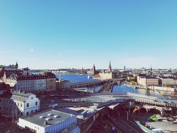 High angle view of city buildings against blue sky