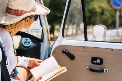 Midsection of woman sitting in car