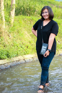 Portrait of smiling woman standing in water