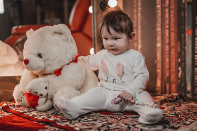 Portrait of cute baby boy sitting on sofa at home