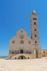 Low angle view of clock tower against clear blue sky