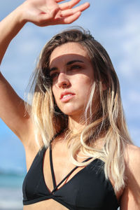 Portrait of young woman standing at beach