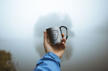 MAN HOLDING COFFEE CUP WITH WATER