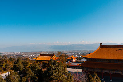 Panoramic view of temple and buildings against clear blue sky