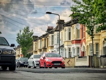 Cars on road against sky in city