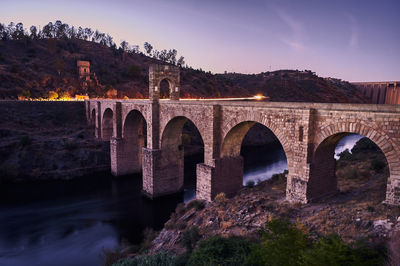 Arch bridge over river against sky