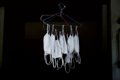 Close-up of clothespins hanging against black background