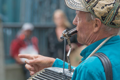 Side view of senior man playing musical instruments