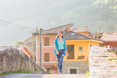 Full length of young woman standing against mountain