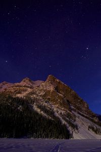 Low angle view of snowcapped mountains in banff national park at night