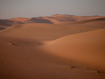 Sand dunes in desert against sky