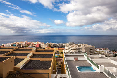 High angle view of buildings by sea against sky