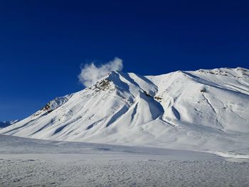 Snowcapped mountain against blue sky