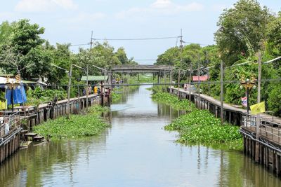 Footbridge over river against sky