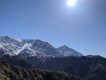 Scenic view of snowcapped mountains against clear blue sky