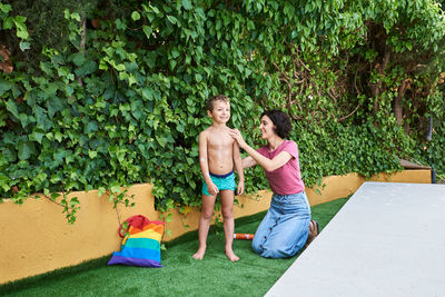 A woman pours sunscreen on a small child. they're on vacation.