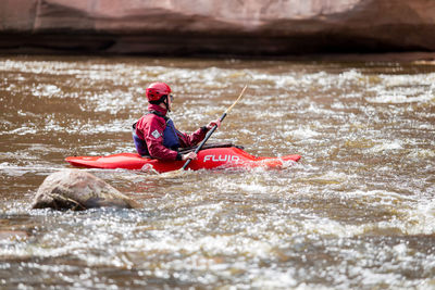 Man sitting on boat in river