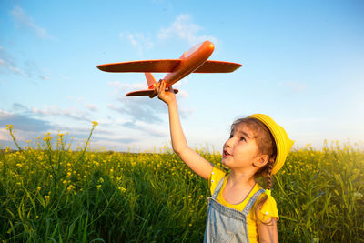 Girl looking away while standing on field