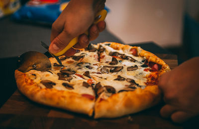 Selective focus of italian pizza, spices in grinders, bottle and glass of wine on wooden tabletop