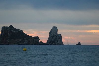 Scenic view of rock formation in sea against sky